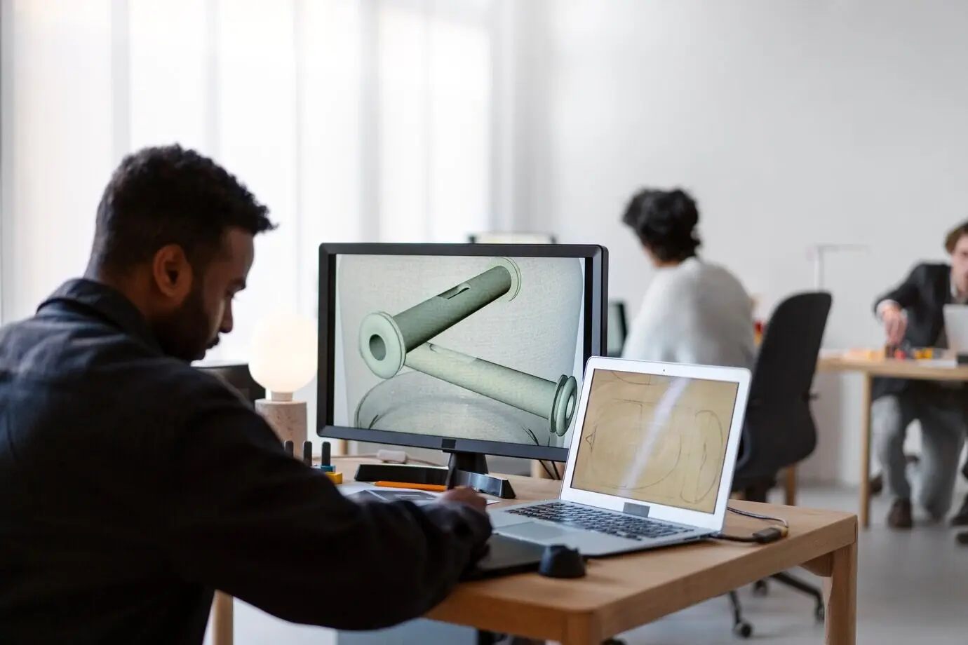 A team of designers working on a 3D model.